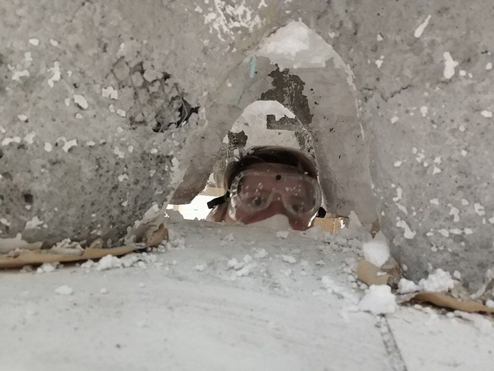 me wearing safety goggles digging out styrofoam off of a molded concrete architectural model